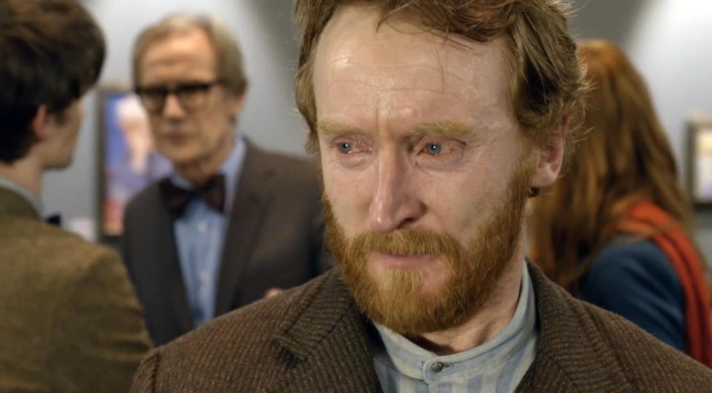 A close up of Vincent van Gogh's face, crying. Behind him stands museum curator wearing bow tie, tweed jacket, and the Doctor and Amy with their backs turned